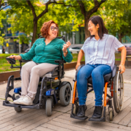 Two friends in wheelchairs talking