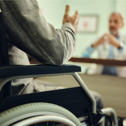 Man in Wheelchair Talking with Doctor
