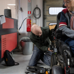 Assistive Technology Professional working on a Power Wheelchair