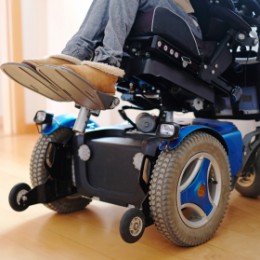 Woman sitting in a blue electric wheelchair. 