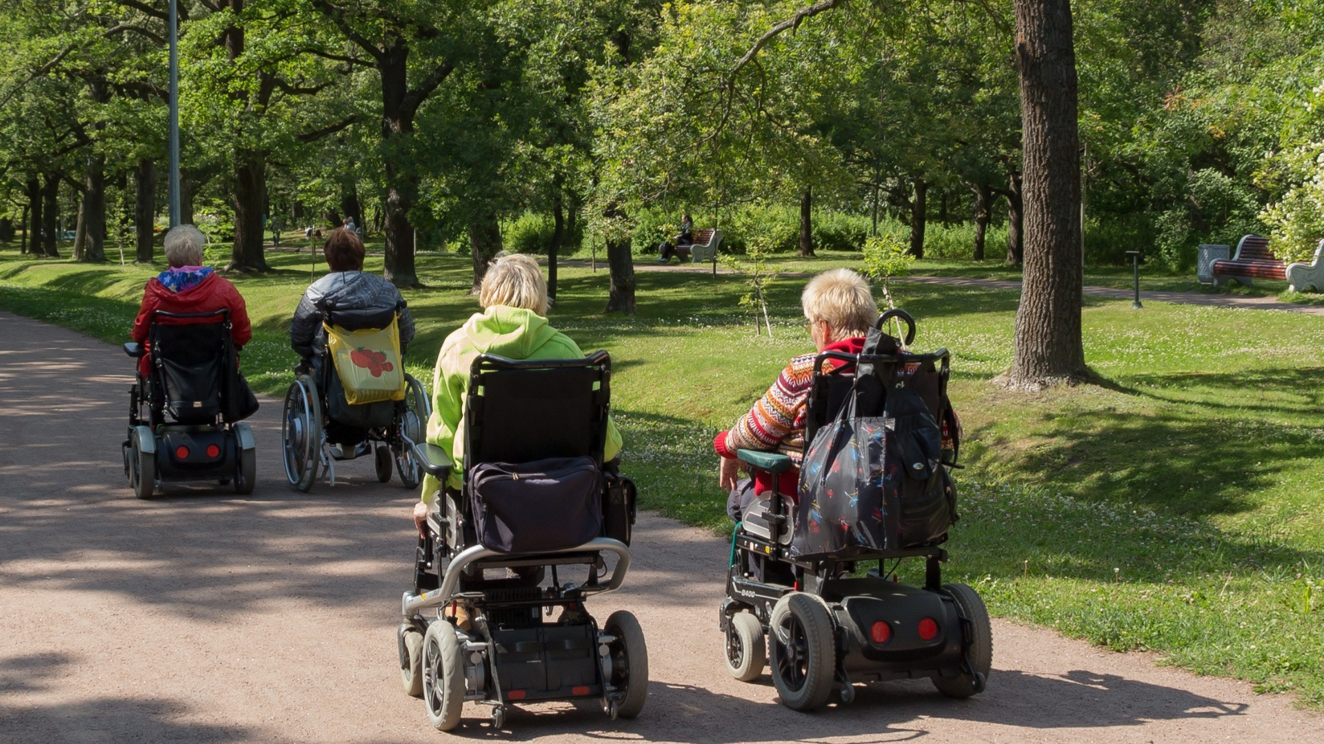Four Power Wheelchairs in the Park