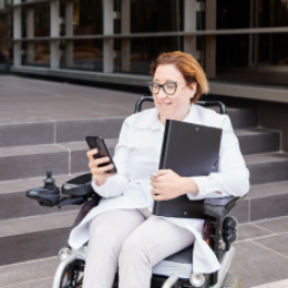 Happy woman in wheelchair using phone