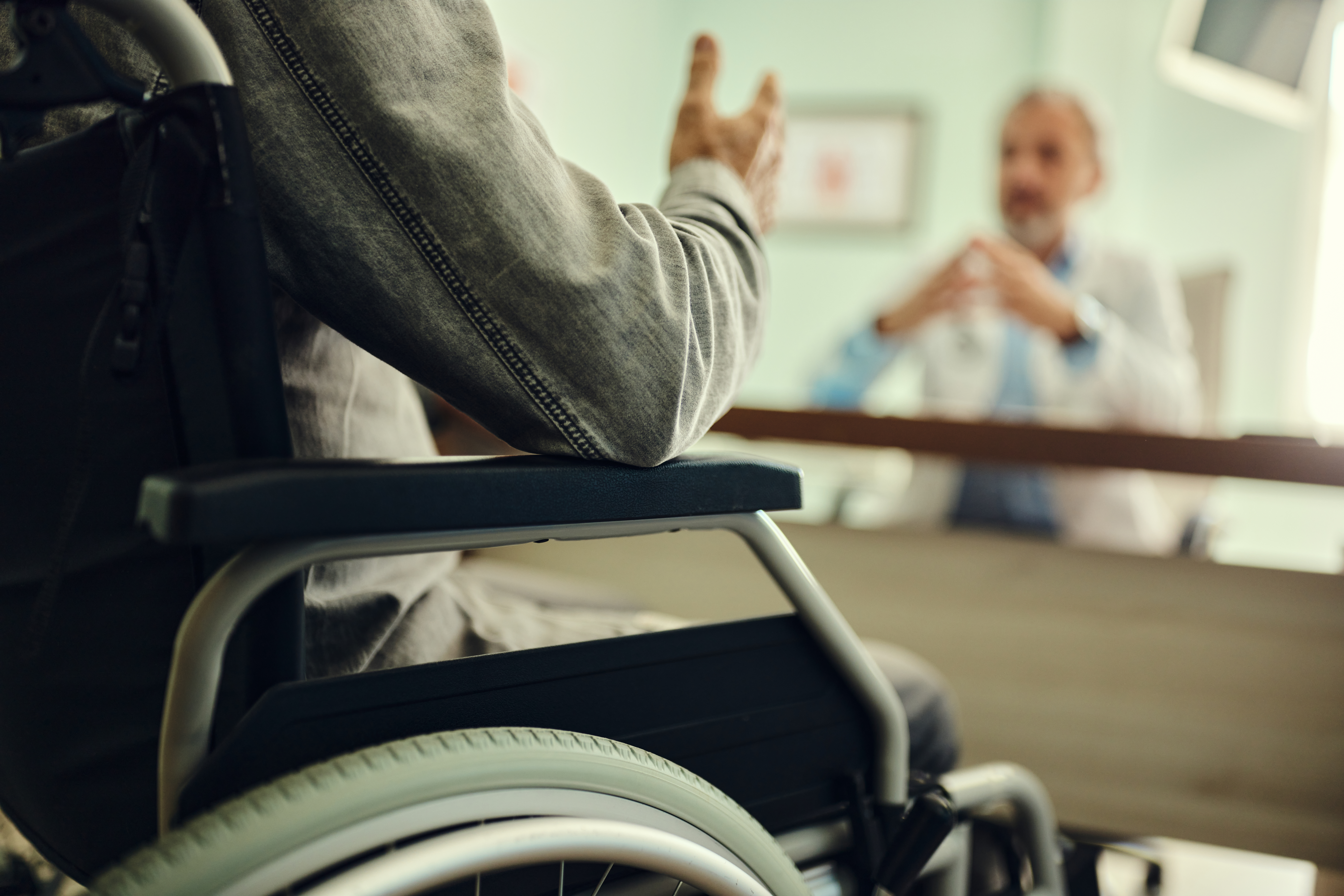 Man in Wheelchair Talking with Doctor