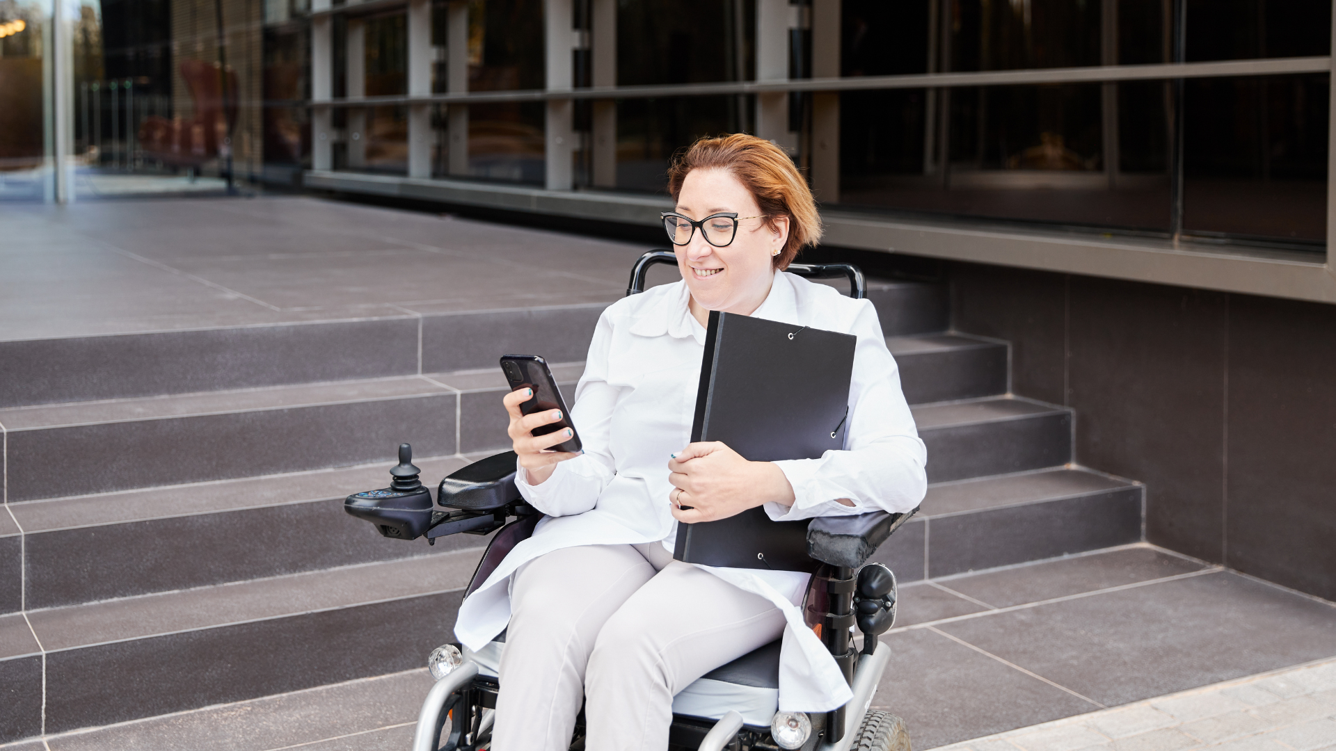 Happy woman in wheelchair using phone