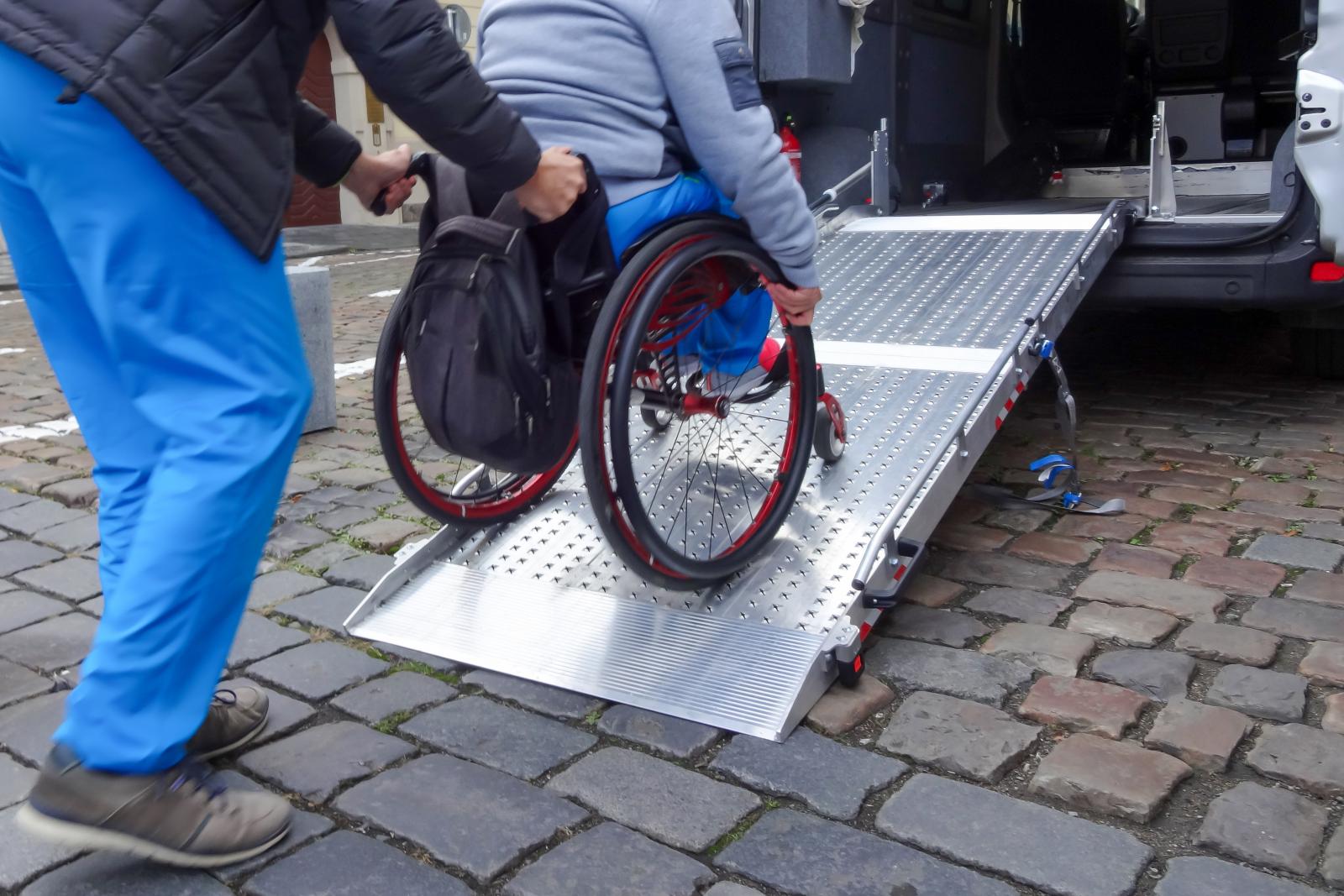 Person entering a vehicle using a wheelchair ramp. 