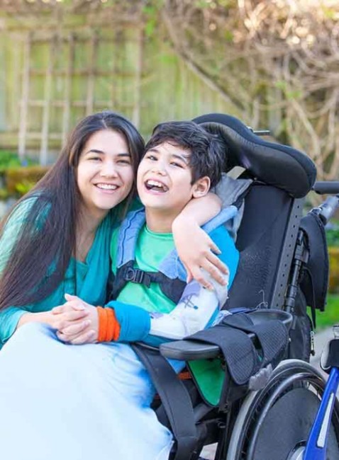 Image of a guy in a wheelchair and his friend walking with him